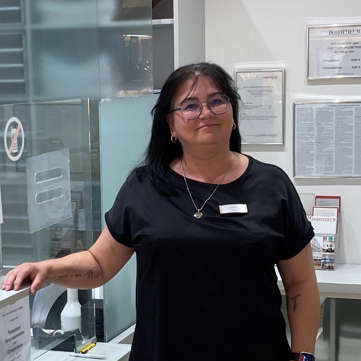 filialleiterin-hinter-einem-schalter-in-schwarzem-shirt