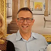 filialleiter-in-blauem-hemd-vor-gemaelde-in-der-filiale