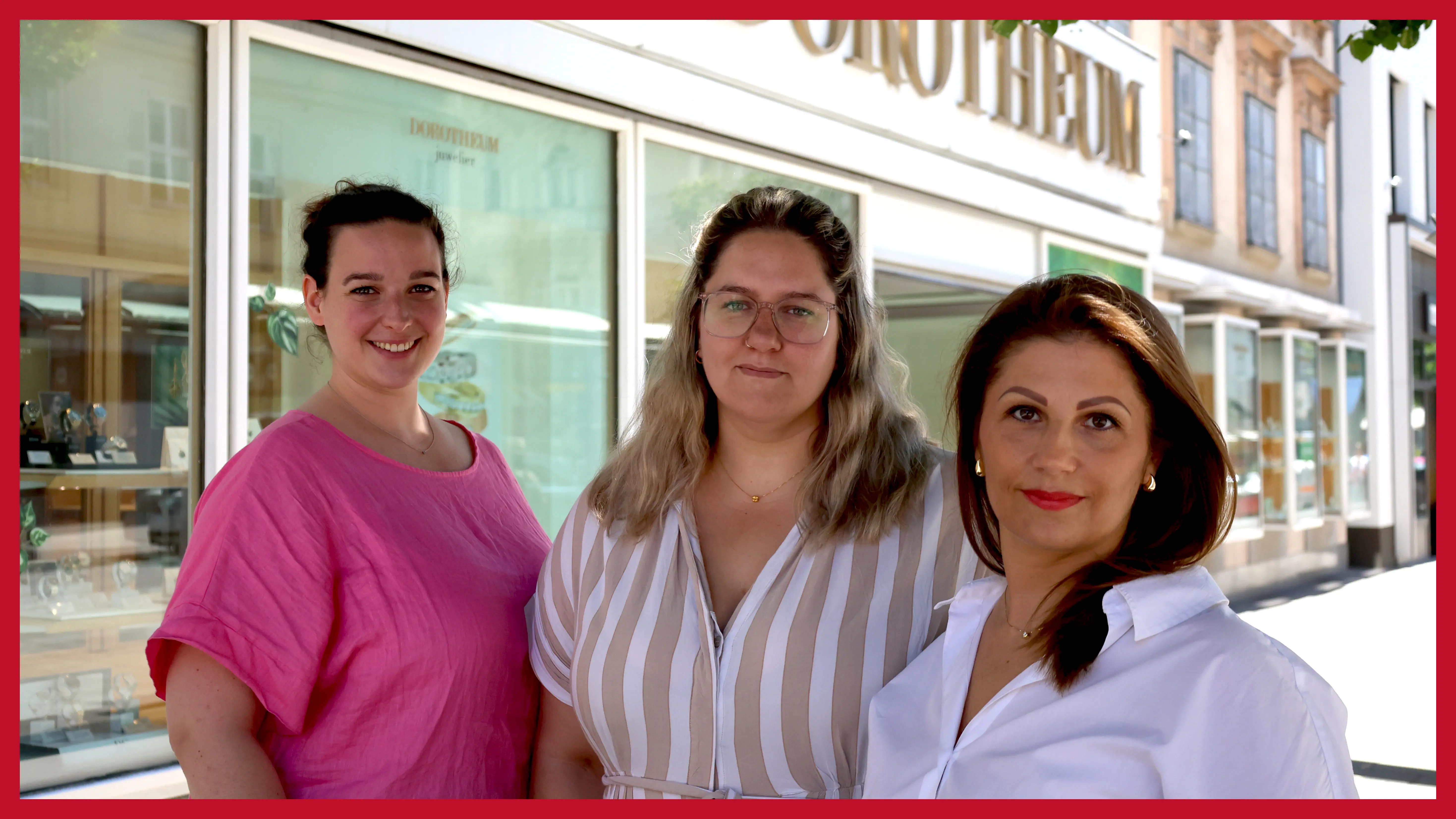 dreikoepfiges-team-steht-im-schatten-unter-einem-baum-vor-der-filiale