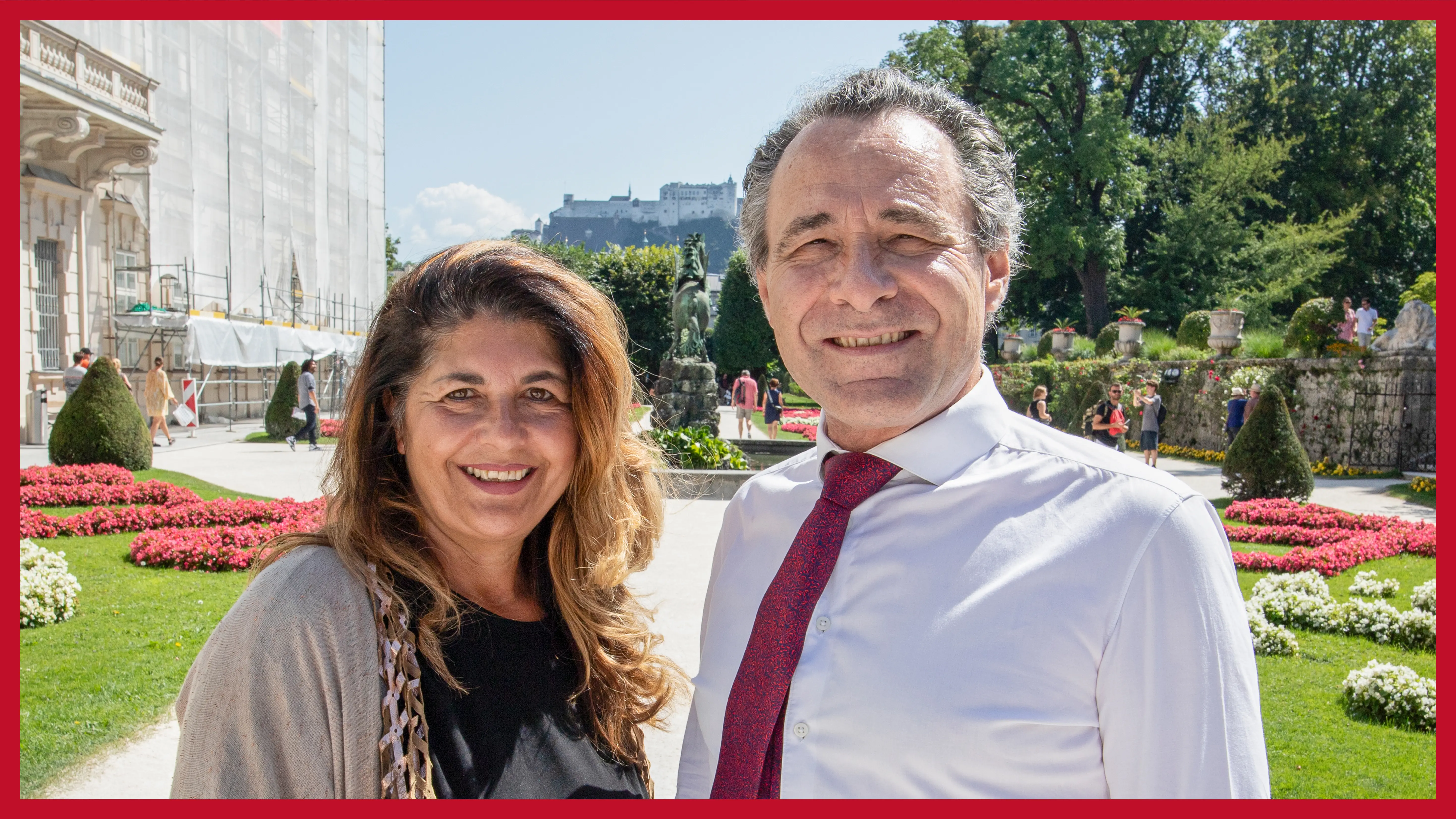 zweikoepfiges-team-draußen-in-einem-park-mit-vielen-blumen-an-einem-sonnigen-tag