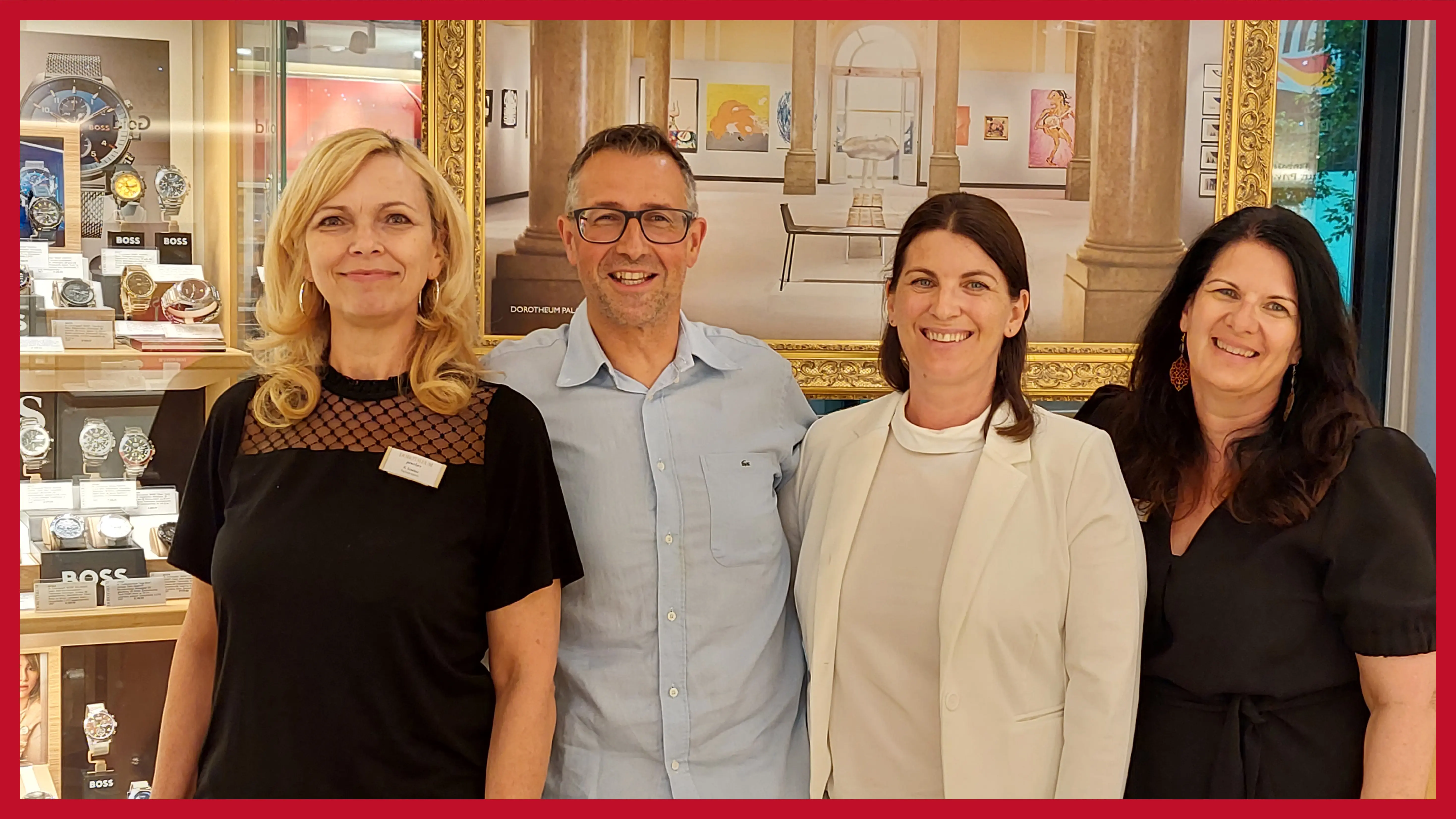 vierkoepfiges-team-in-der-filiale-vor-gemaelden-und-vintrinen