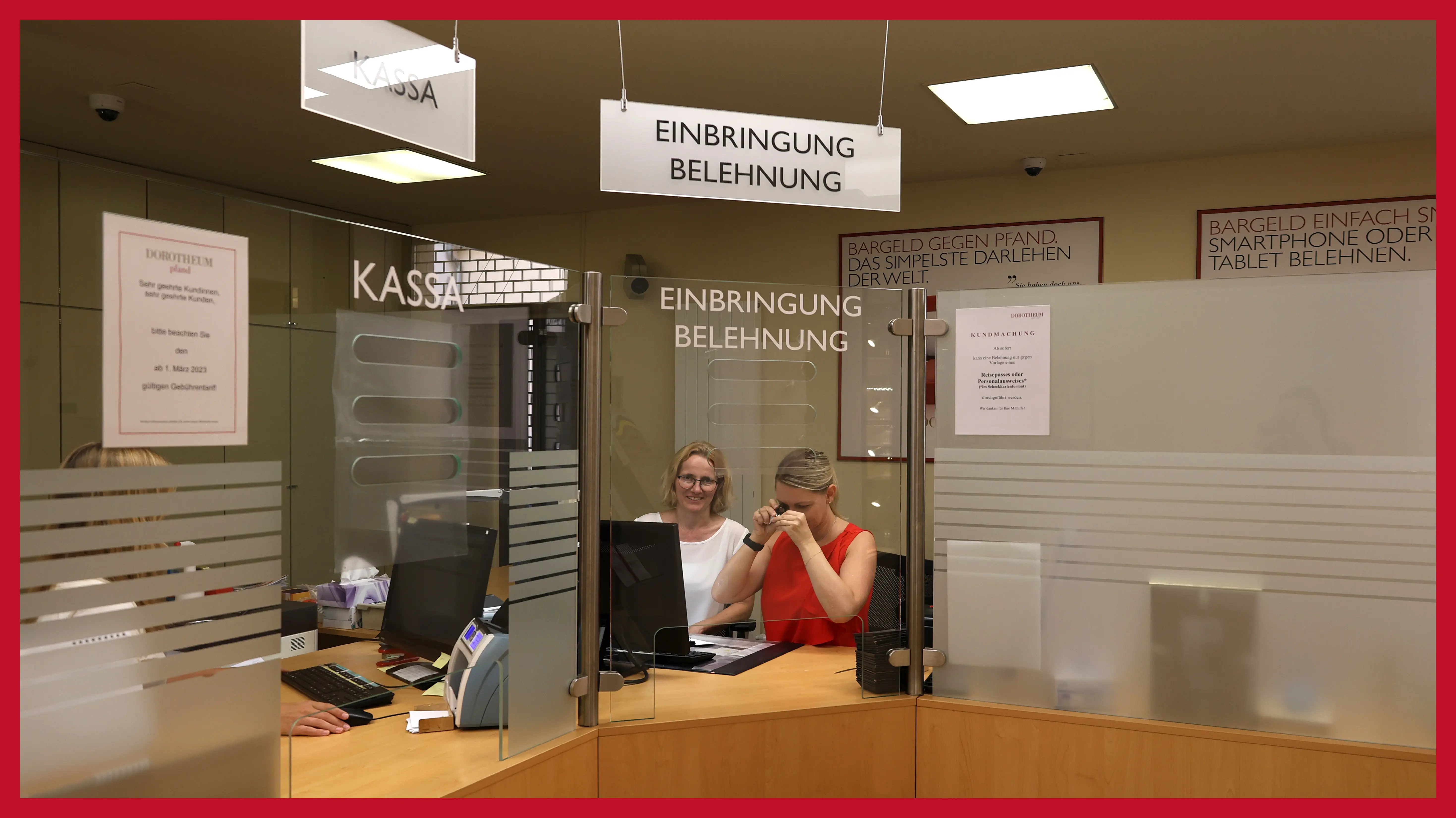 zwei-damen-sitzen-hinter-einem-schalter-und-begutachten-schmuckstueck