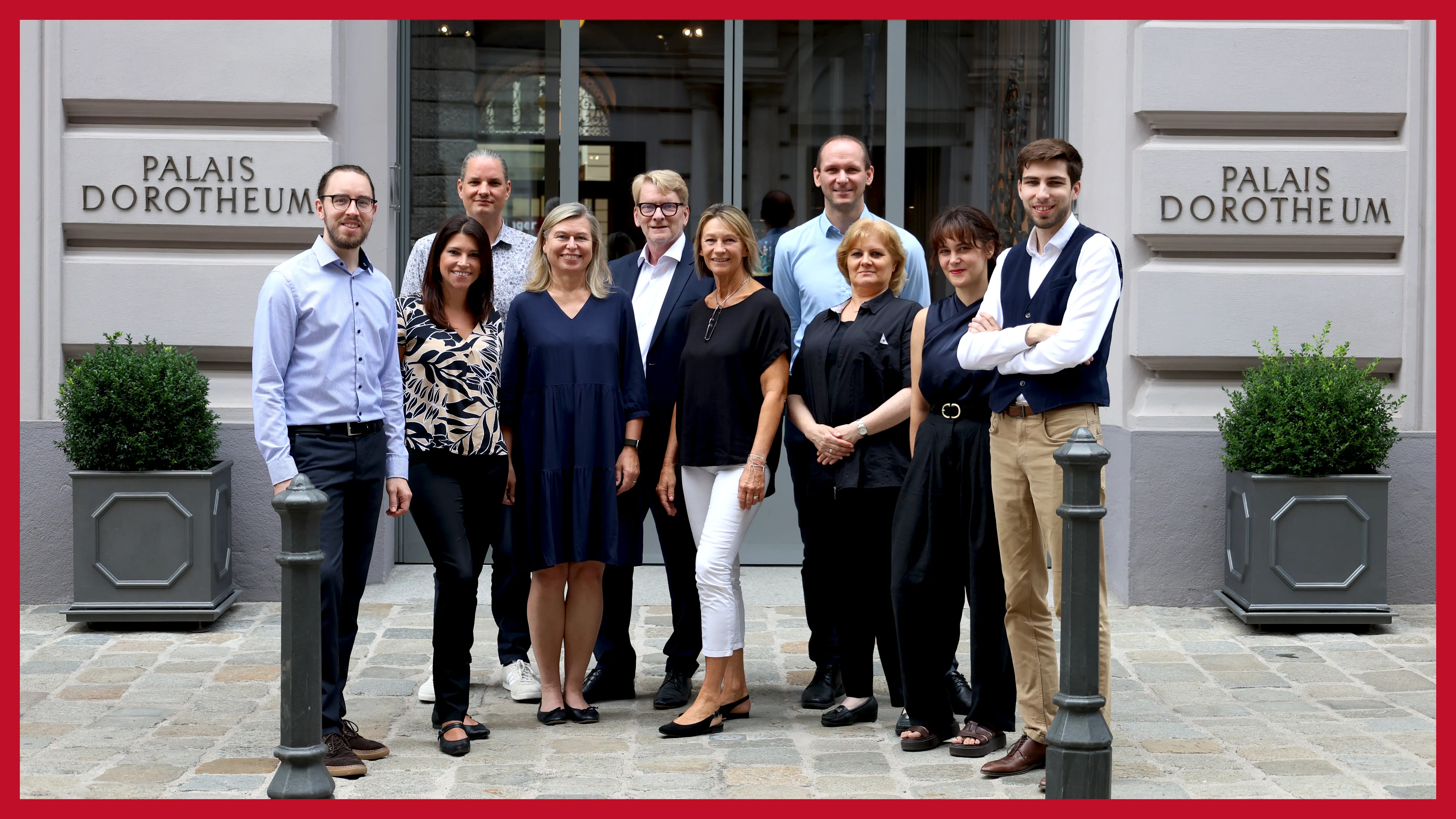 neun-personen-stehen-vor-der-filiale-im-ersten-berzirk-an-einem-sonnigen-tag