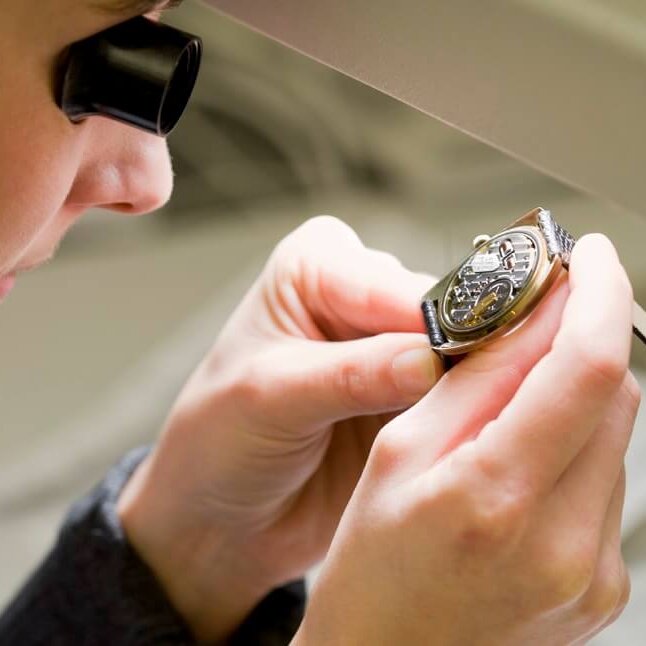 Schätzmeister mit Lupe und Uhr im Dorotheum