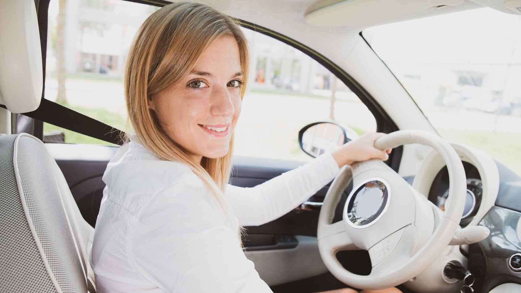 Junge Frau am Steuer ihres Autos