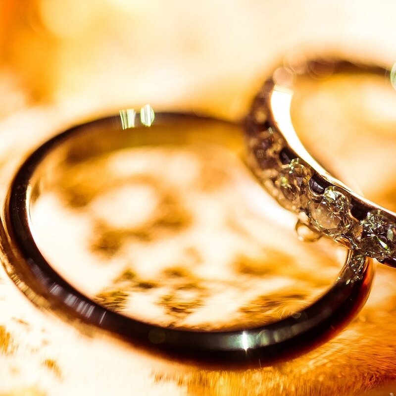 ein Paar Eheringe auf orangem Hintergrund.