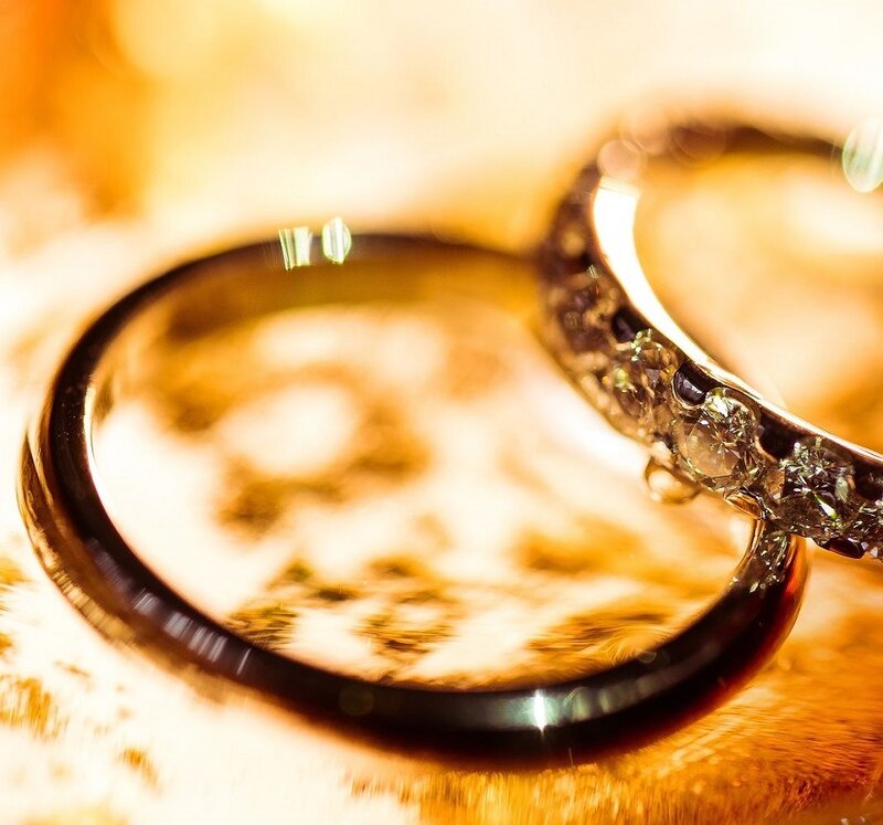 ein Paar Eheringe auf orangem Hintergrund.