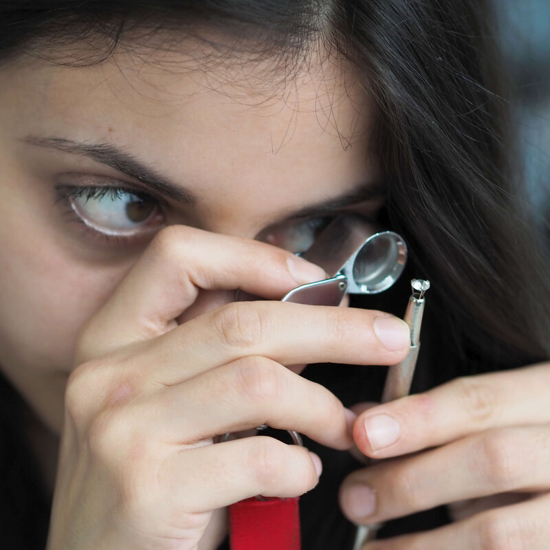 Schätzmeisterin mit Lupe und Schmuck