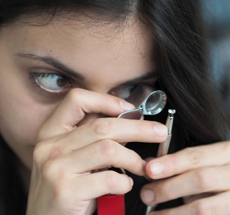 Schätzmeisterin mit Lupe und Schmuck