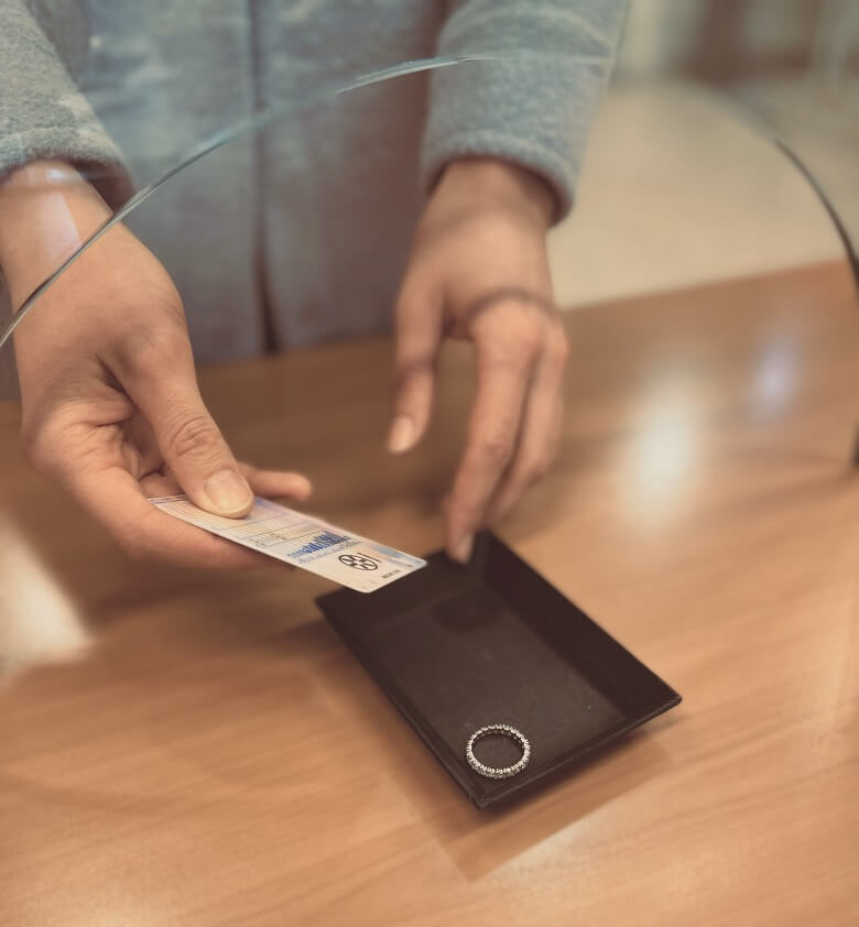 Übergabe von Ausweis und Pfand im Pfandleihhaus Dorotheum.