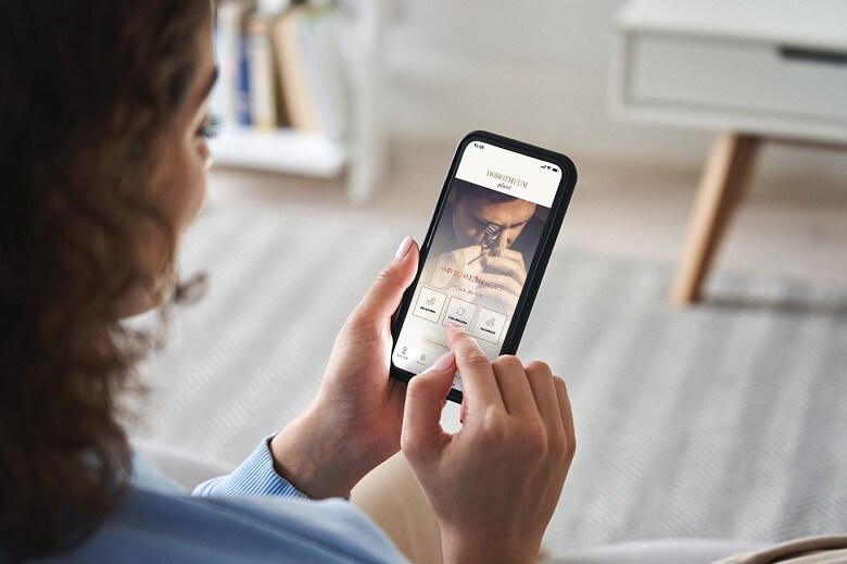 Eine junge Frau bedient die Dorotheum Pfand App