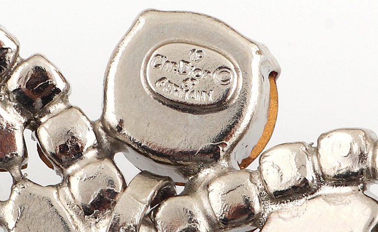 Rückseite eines Modeschmucks von Christian Dior mit Herstellerzeichen